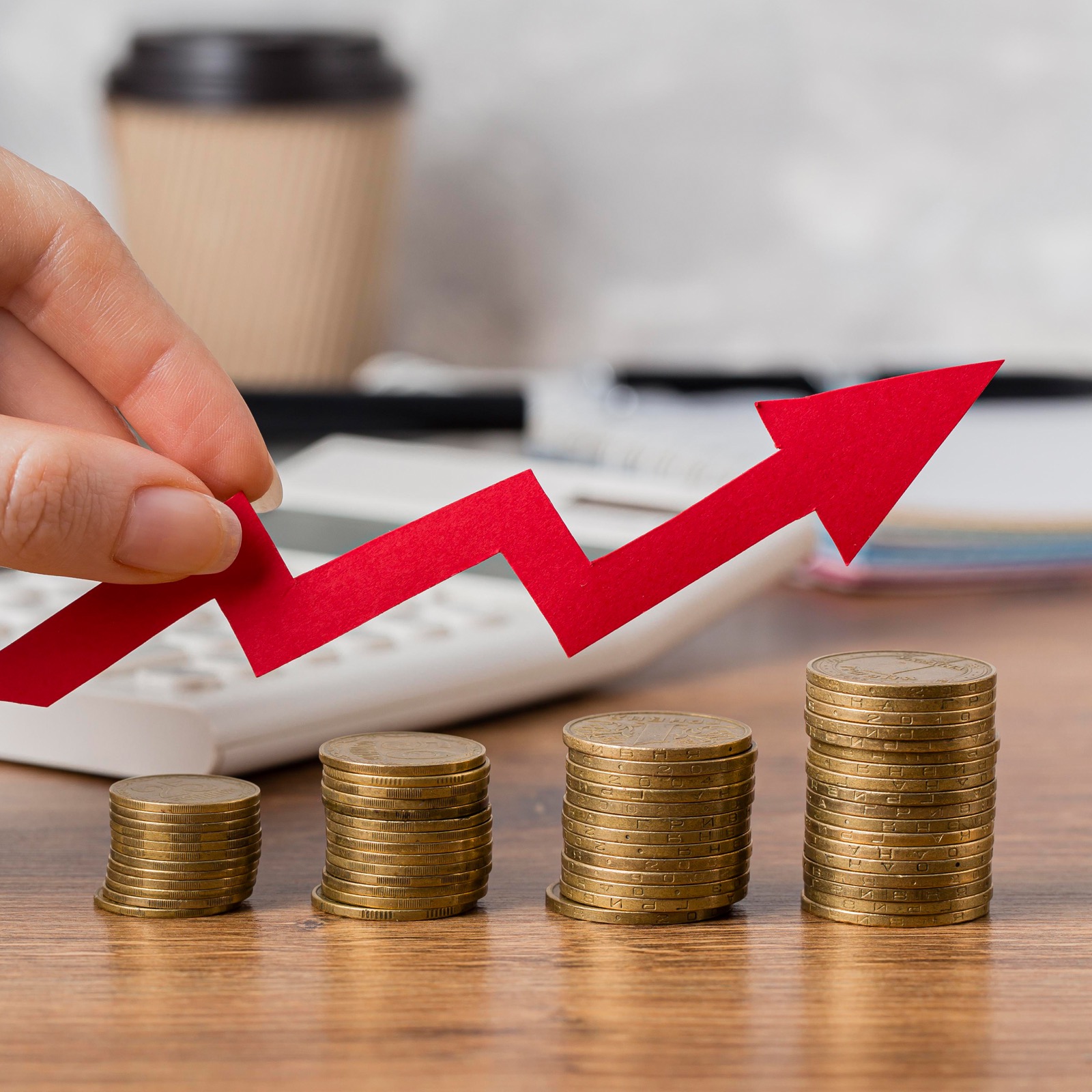 Rising red arrow over stacks of coins